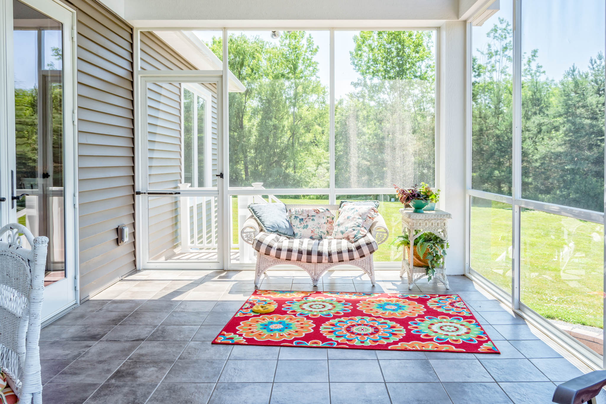 Sunroom with glazing on three sides looking out to the lawn