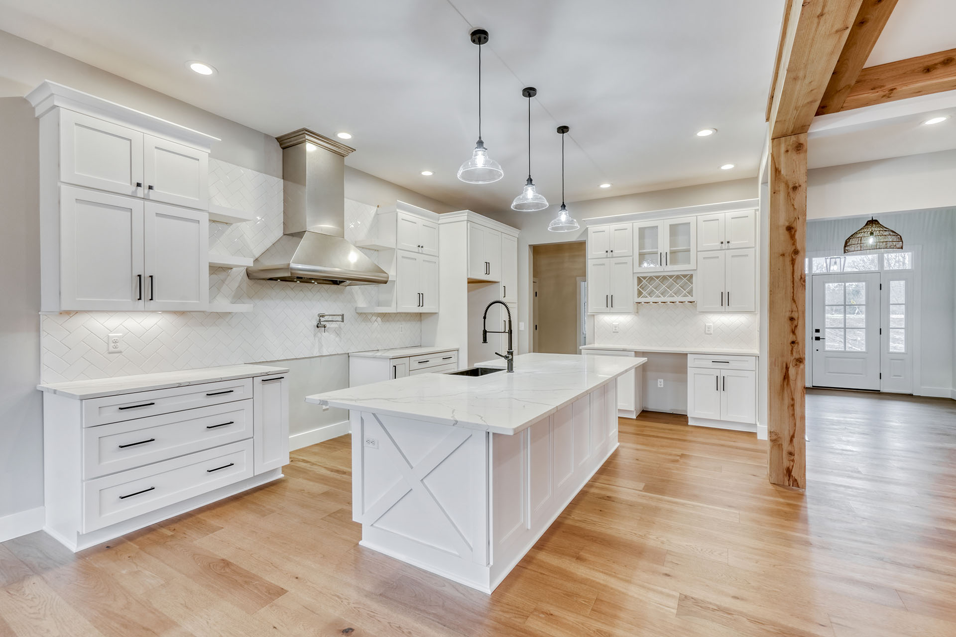 White kitchen with task lighting over a broad island